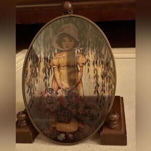 Vintage amber stained glass with girl holding a flower basket. Brass rim.